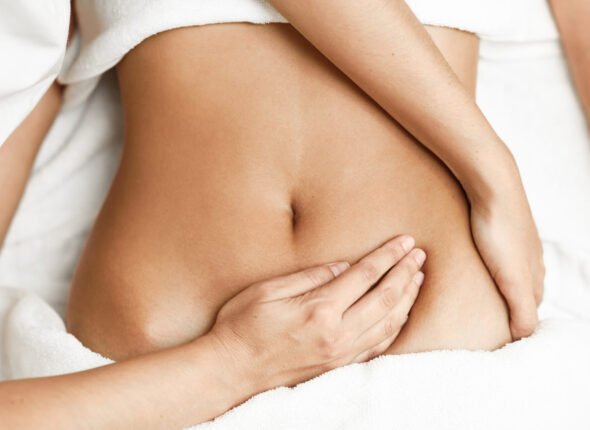 Hands-massaging-female-abdomen.Therapist-applying-pressure-on-belly.-854292120_3866x2580-scaled